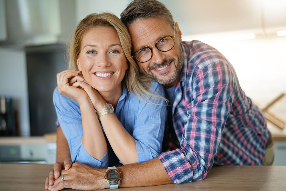 Portrait of mature couple standing in home kitchen-1000x670