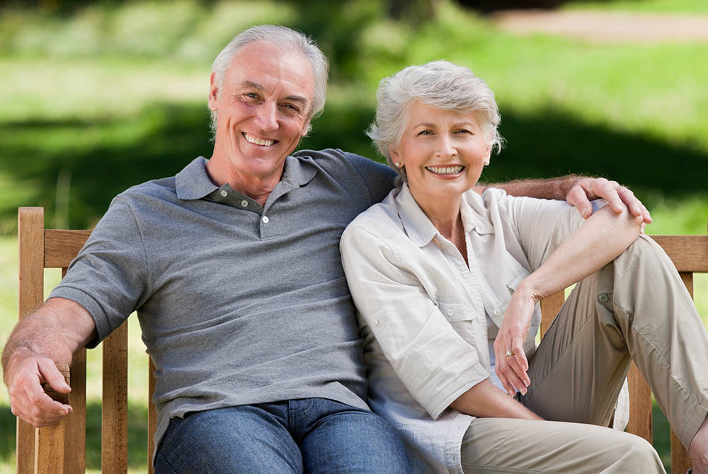Senior couple sitting on a bench-1000x670
