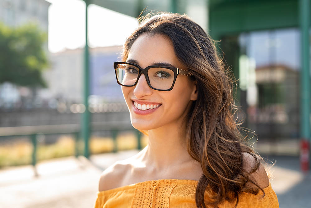 Smiling woman wearing eyeglasses outdoor-1000x670